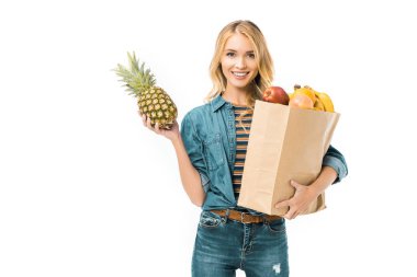 ananas ve kağıt çanta üzerinde beyaz izole ürünleri ile tutan genç kadın portresi