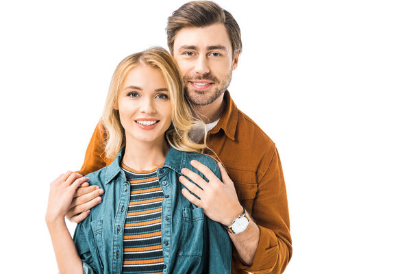 handsome young man embracing girlfriend from behind isolated on white 