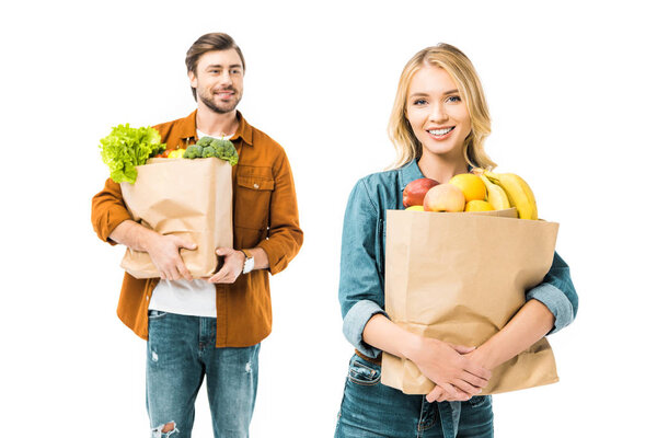 beautiful girl holding paper bag with food while her boyfriend standing behind isolated on white