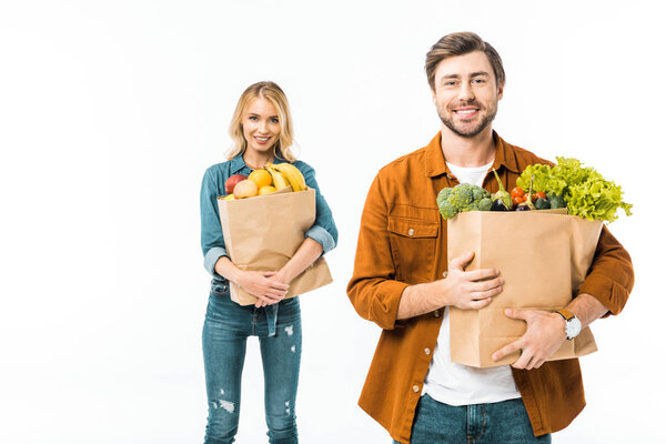 man holding shopping bag with products while his girlfriend standing behind isolated on white