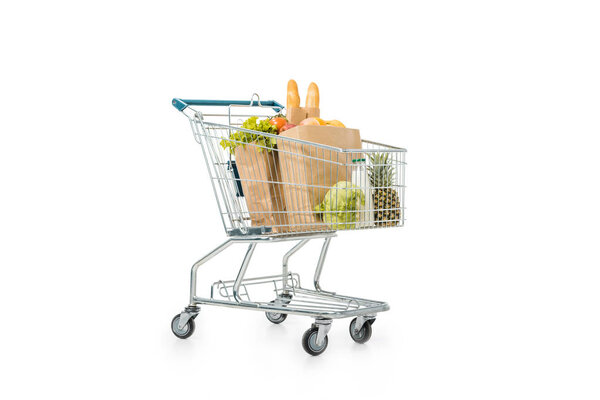 shopping trolley with paper bags full of products isolated on white 