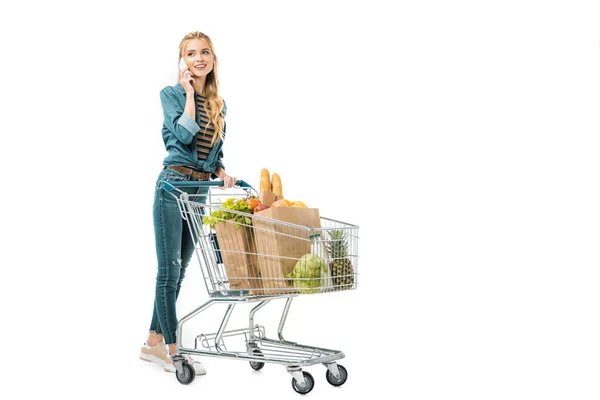 Piękna Kobieta Rozmawia Smartfonie Prowadzenie Wózka Zakupy Produktów Białym Tle — Zdjęcie stockowe