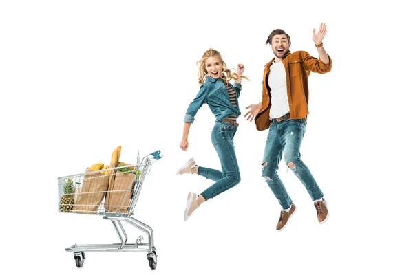 Glada Unga Par Hoppning Nära Shopping Vagn Full Produkter Papperspåsar — Stockfoto