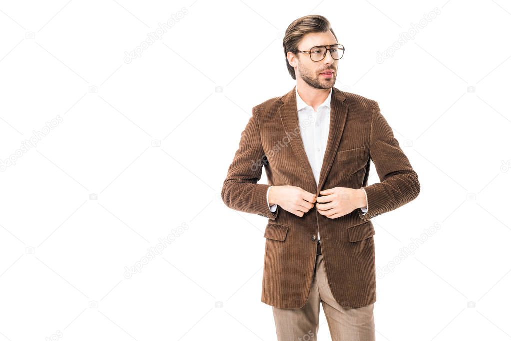 handsome male model in eyeglasses buttoning up velvet jacket isolated on white