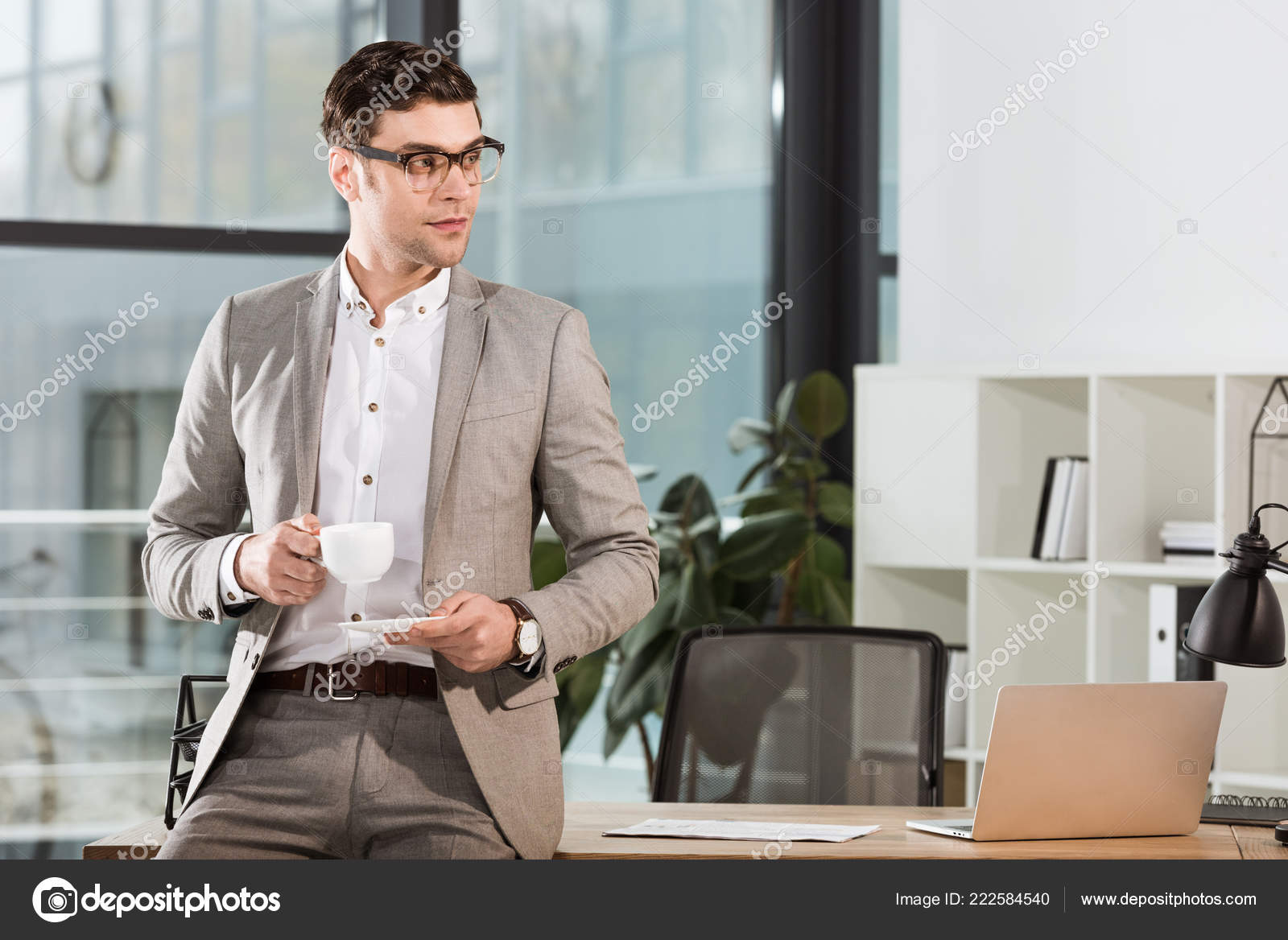 Hombre Negocios Guapo Con Taza Café Apoyado Lugar Trabajo Mirando — Foto de  stock #222584540 © EdZbarzhyvetsky, image size:1600x1168