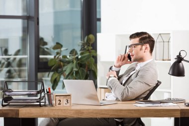 modern ofis işyerinde telefonla konuşurken başarılı emin iş adamı