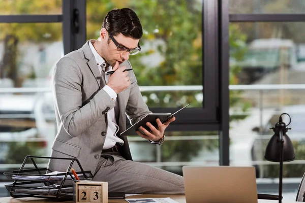 Fokussierter Gutaussehender Geschäftsmann Mit Notizbuch Sitzt Arbeitsplatz Büro — kostenloses Stockfoto