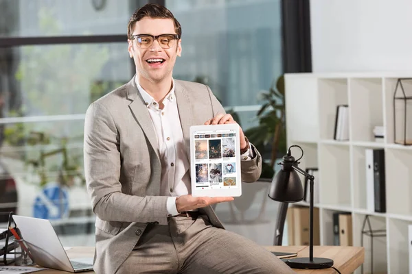 Przystojny Biznesmen Szczęśliwy Biurku Pracy Trzymając Tablet Witryny Pinteresta Ekranie — Zdjęcie stockowe