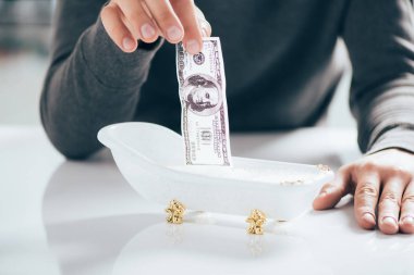 bir dolarlık banknot küçük küvet, kara para aklama kavramı yıkama adam kısmi görünümü  