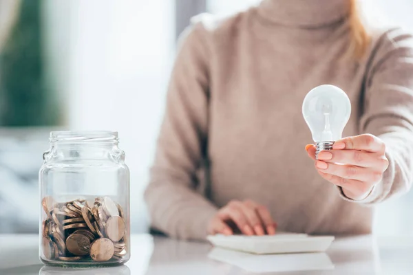 Vergrote Weergave Van Glazen Pot Met Munten Vrouw Met Gloeilamp — Stockfoto