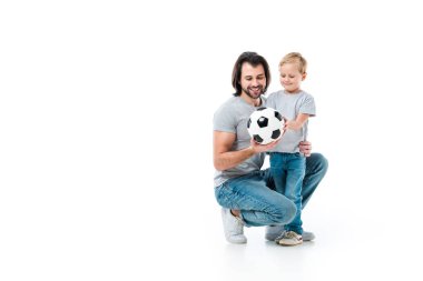 Baba ve birbirlerine sarılma ve futbol topu üzerinde beyaz izole bakarak onun küçük bir çocuk