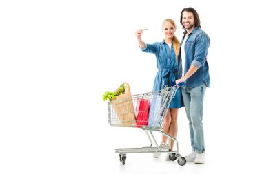 Alışveriş sepeti kredi kartı üzerinde beyaz izole gösteren çanta dolu ile güzel çift