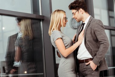 sarılma iş adamları görünümünü yan ve birbirine bakarak ofisinde, flört ve office romance kavramı