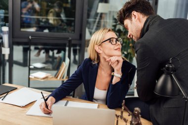 Avukatlar ofiste dizüstü bilgisayar ile işyerinde flört ederken birbirine bakarak