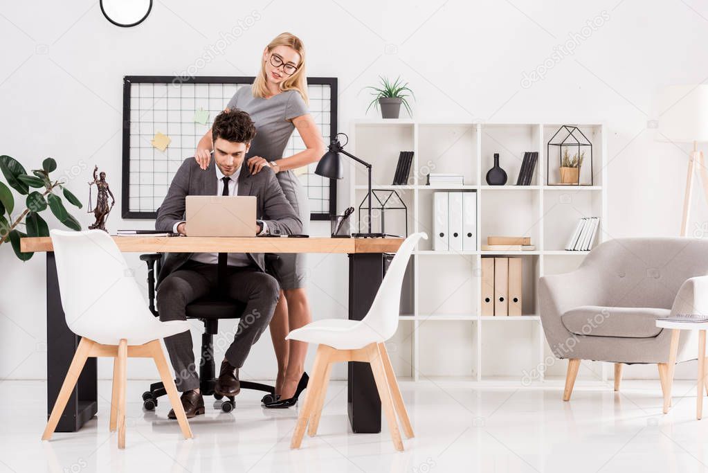 businesswoman making massage to colleague at workplace in office, office romance concept