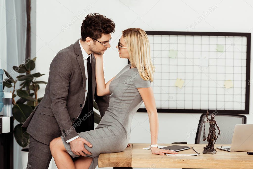 side view of young business colleagues flirting at workplace in office