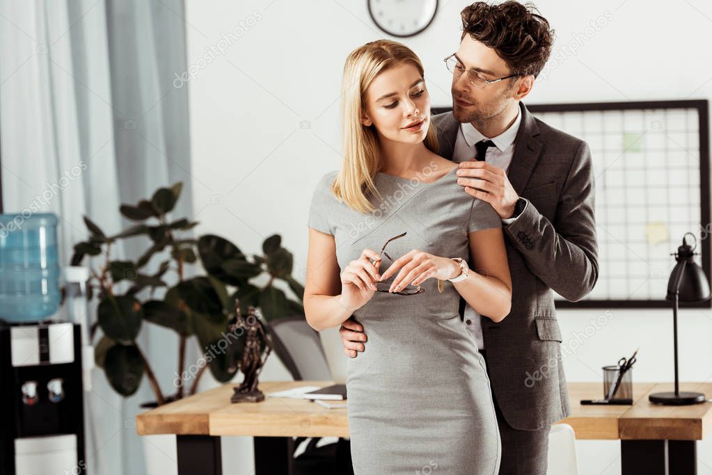 young lawyers flirting during work day in office, office romance concept