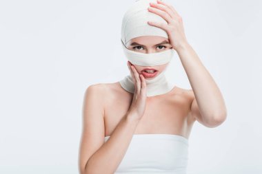 Plastik cerrahi üzerine beyaz izole kafa dokunmadan sonra bandaj ile kadın