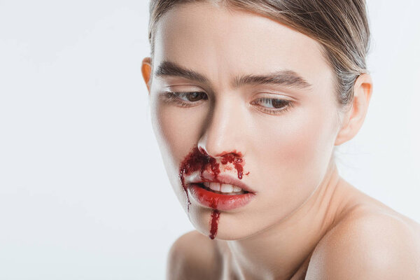 крупным планом грустной раненой женщины с кровью на лице после домашнего насилия, изолированного на белом
