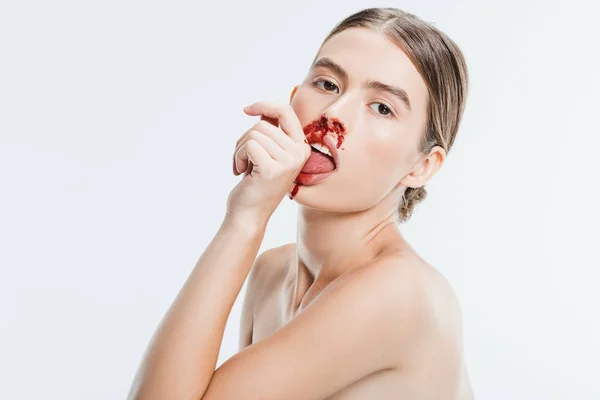 naked woman with injury on face licking blood from hand isolated on white