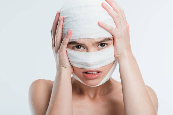 close up of woman with bandages over head isolated on white