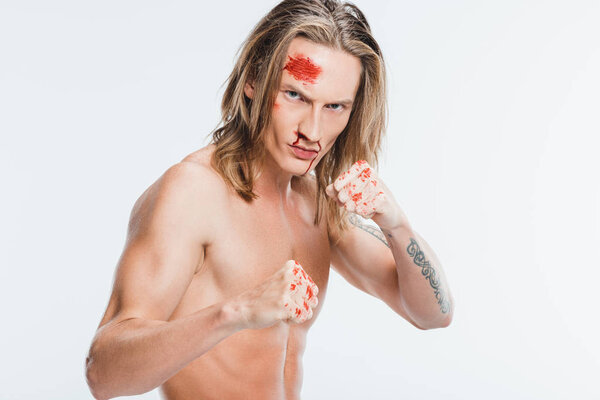 angry adult man with blood on face ready to fight isolated on white