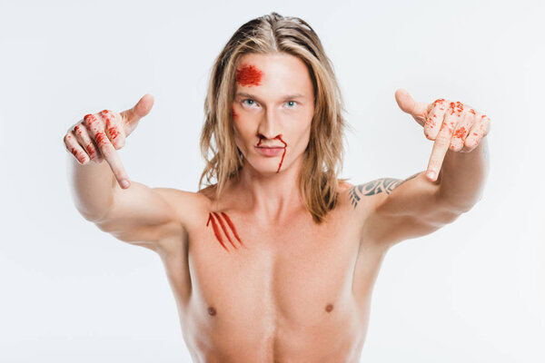 nude handsome man with bloody wounds showing middle fingers isolated on white