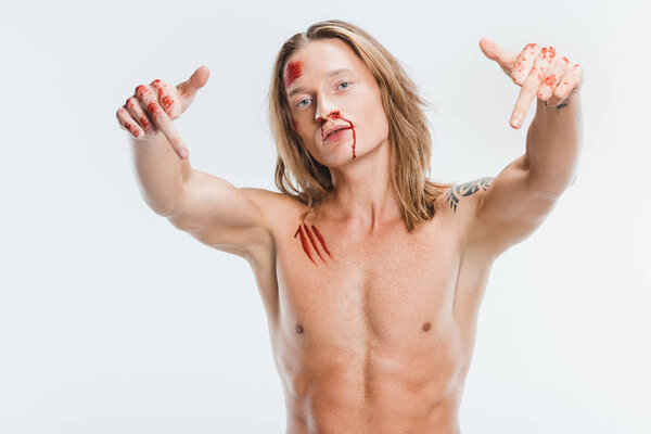 nude handsome man with bloody wounds showing middle fingers isolated on white