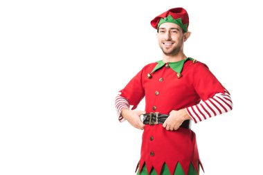 neşeli Noel elf kostümü kameraya ellerle kalça üzerinde beyaz izole seyir erkekte