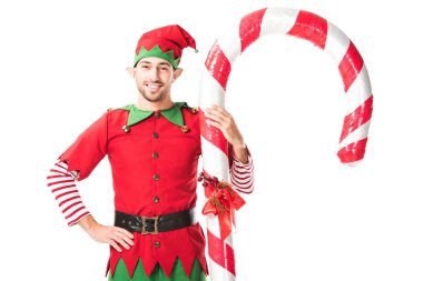Noel elf kostümü büyük şeker ayakta kalça üzerinde el ile kamışı izole üzerinde beyaz adam gülümseyen