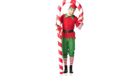 Noel elf kostüm üzerine beyaz izole büyük şeker kamışı altında duran adam