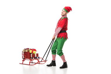 Adam Noel elf kostümü crrying yığın armağan üstünde üzerinde beyaz izole atlı kızak