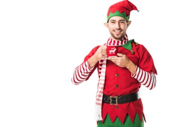 çay tutarak ve üzerinde beyaz izole kamera bakarak Noel elf kostümü erkekte gülümseyen