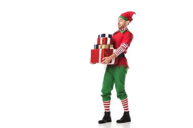 Noel elf kostümü yığın üzerinde beyaz izole hediye taşıyan adam