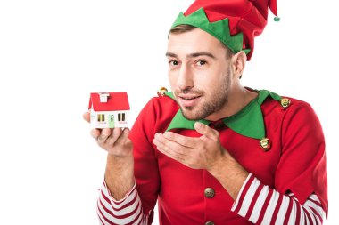 Beyaz, gayrimenkul satış ve sigorta kavramı üzerinde adam Noel elf kostüm evi modeline işaret izole