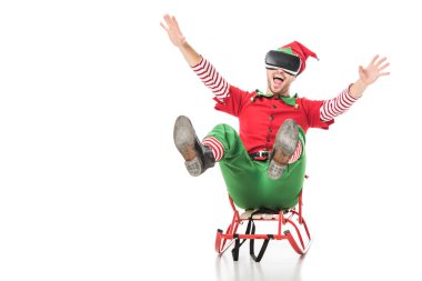 excited man in christmas elf costume riding sleigh and wearing virtual reality headset isolated on white clipart
