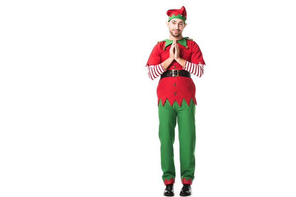 man in christmas elf costume holding palms together as please gesture and having hopeful expression isolated on white