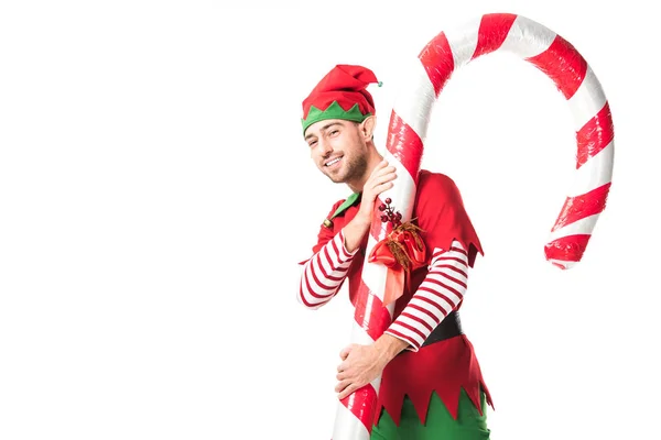 クリスマス エルフ衣装白で隔離運ぶ大きなキャンディの杖の男に笑みを浮かべてください — ストック写真
