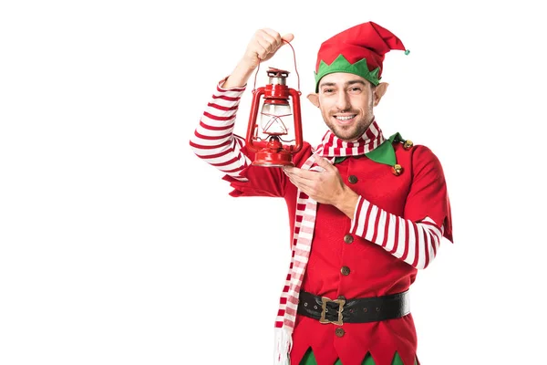 クリスマス エルフ衣装赤ランタンを押しながら白で隔離カメラ目線で陽気な男  — 無料ストックフォト