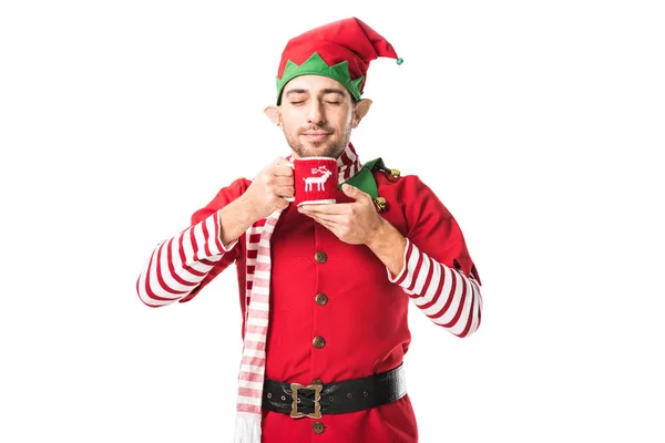 エルフのクリスマスの衣装で男目を閉じて一杯のお茶を押しながら白で隔離の香りを吸い込む  — 無料ストックフォト