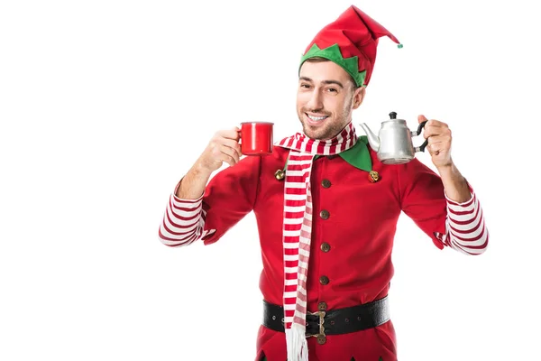 happy man in christmas elf costume holding red cup and metal kettle isolated on white