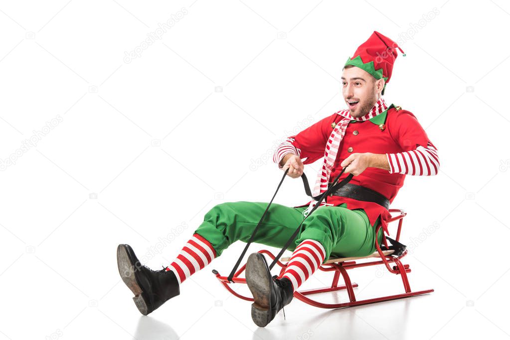 excited man in christmas elf costume riding sleigh isolated on white background