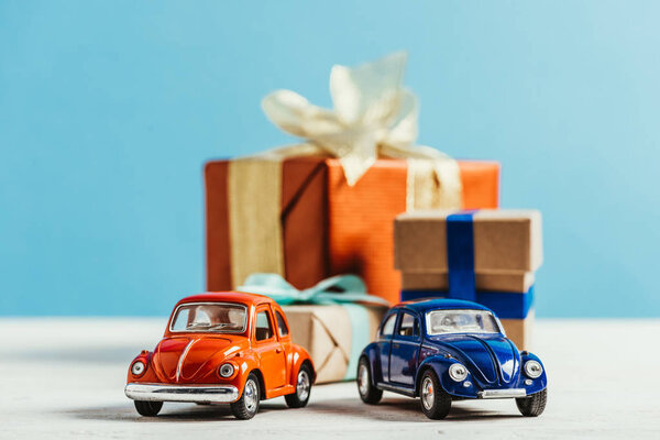 close-up shot of toy cars with christmas gift boxes on blue background