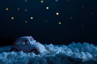 close-up shot of toy car standing in snow in night under starry sky, christmas concept clipart
