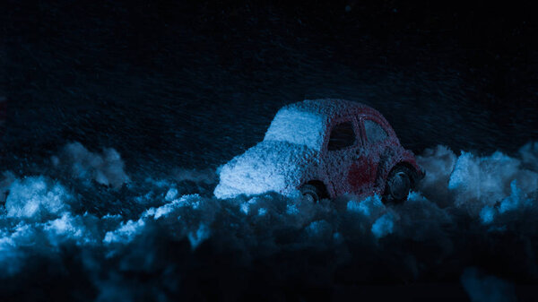 close-up shot of toy car covered with snow in night