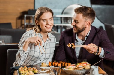 Çekici çift gülümseyen birlikte suşi yemek restoranda rulo 