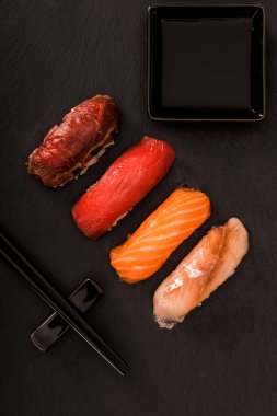 Top view of delicious sashimi sushi on black slate clipart