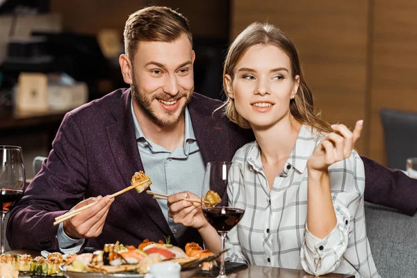 Sonriente Pareja Adultos Jóvenes Comiendo Rollos Sushi Restaurante — Foto de Stock