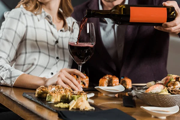 Částečný Pohled Člověka Nalévá Červené Víno Skle Pár Večeři Restauraci — Stock fotografie