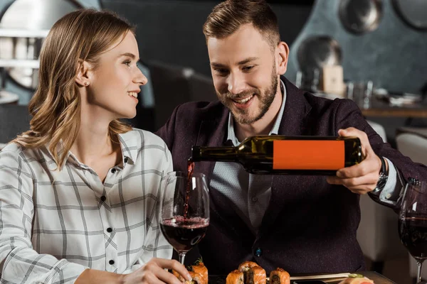 Attraktivt Leende Par Middag Och Man Hälla Vin Glas Restaurang — Gratis stockfoto